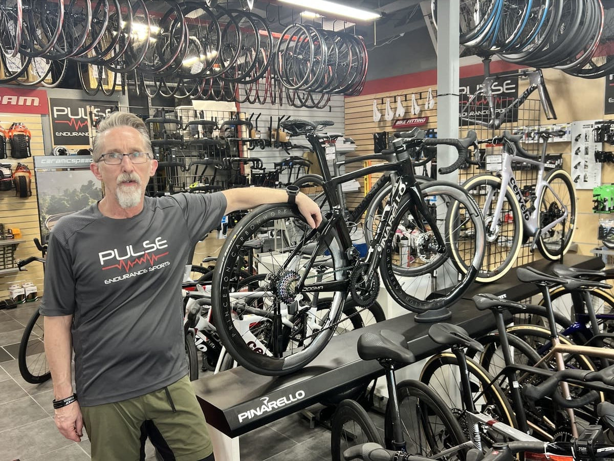 Shop bike fitter Matt Mazzone person adjusting a bicycle on a stand in a bike shop